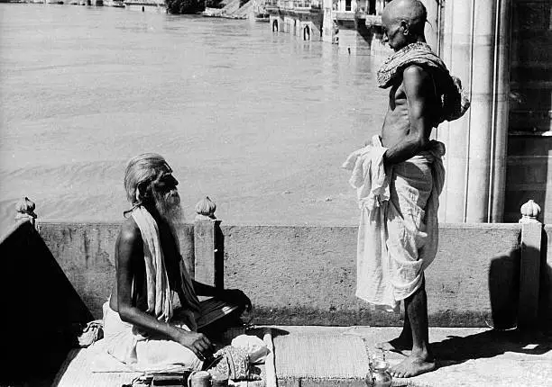 India A Brahman consecrates a pilgrim in Benares in the backgr- 1955 Old Photo