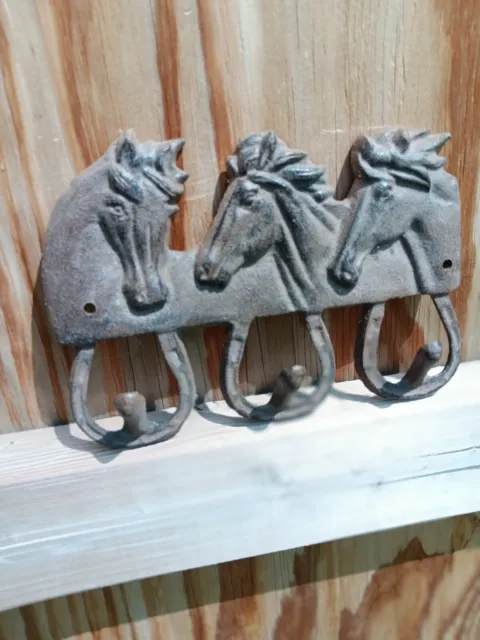 three horses three hooks wall hanging made out of cast iron Brown