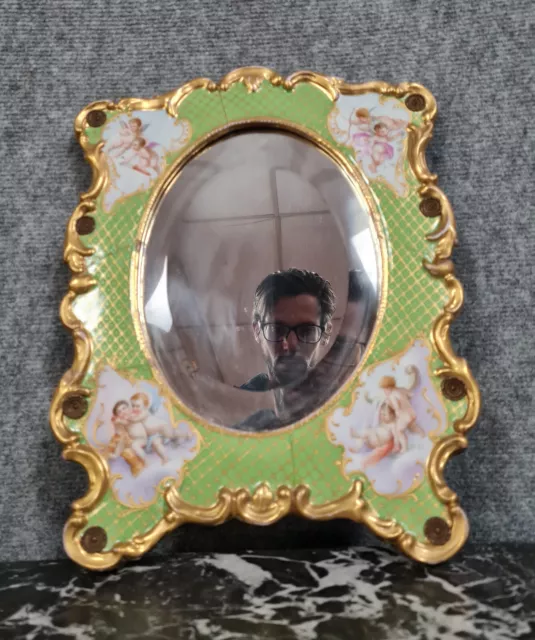 Joli miroir en porcelaine à décors d'angelots vers 1900