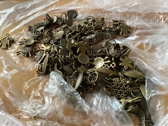 JOB LOT OF CRAFTING CHARMS APPROX 100. Brass coloured metal (11)