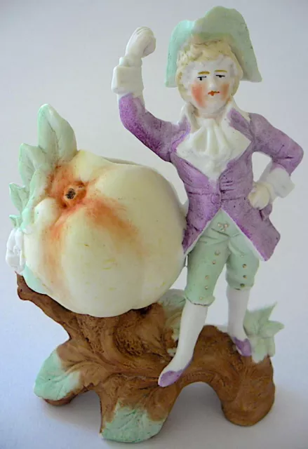 Groupe en biscuit de porcelaine représentant un personnage tenant un fruit