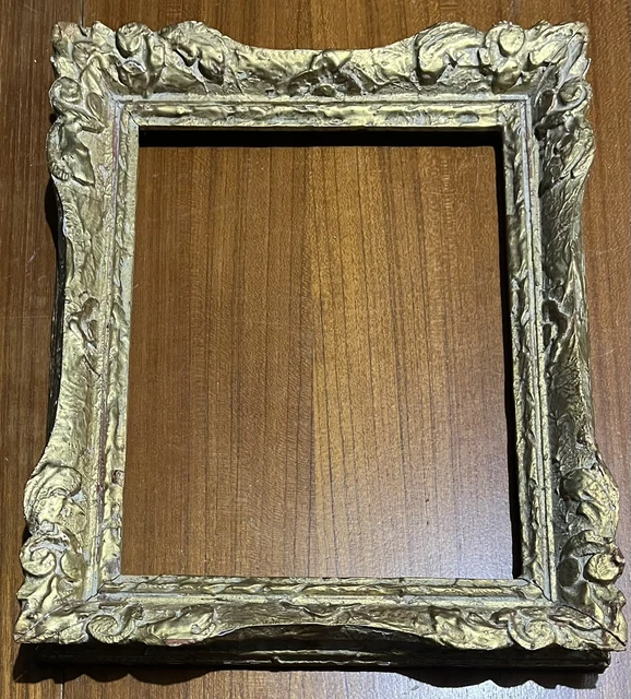 Un cadre doré sur un mur en bois avec un motif floral. | Image générée