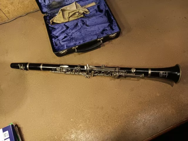 Bb clarinet in a hard case with reeds, cleaning rag, and cork grease