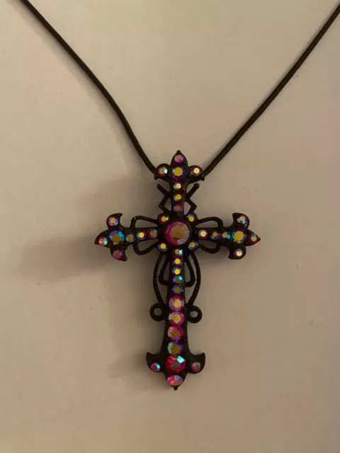 black cross set with iridescent red stones on black snake chain